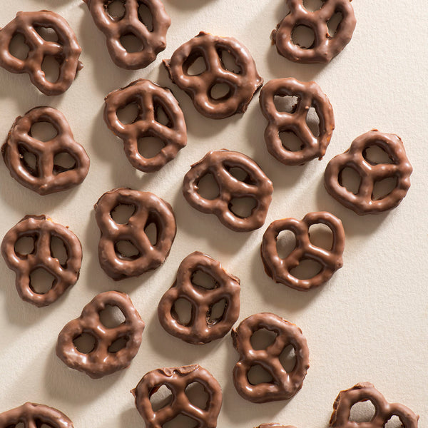 A collection of milk chocolate-coated pretzels arranged on a surface.