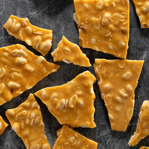 Pieces of peanut brittle on a dark surface