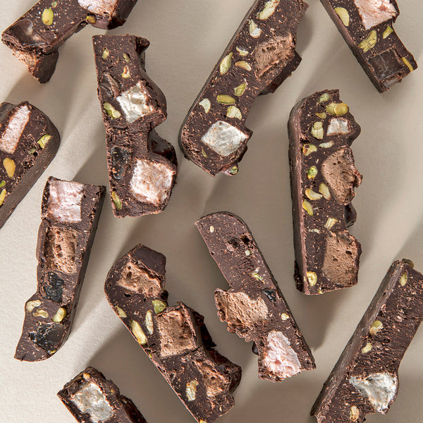 Chopped pieces of dark chocolate rocky road assortment, showing chunks of marshmallows, pistachios, and pieces of Turkish delight within.